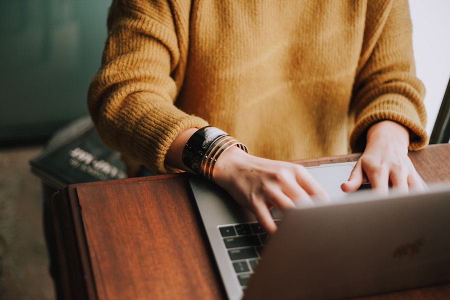 Person using a laptop computer at a wooden desk